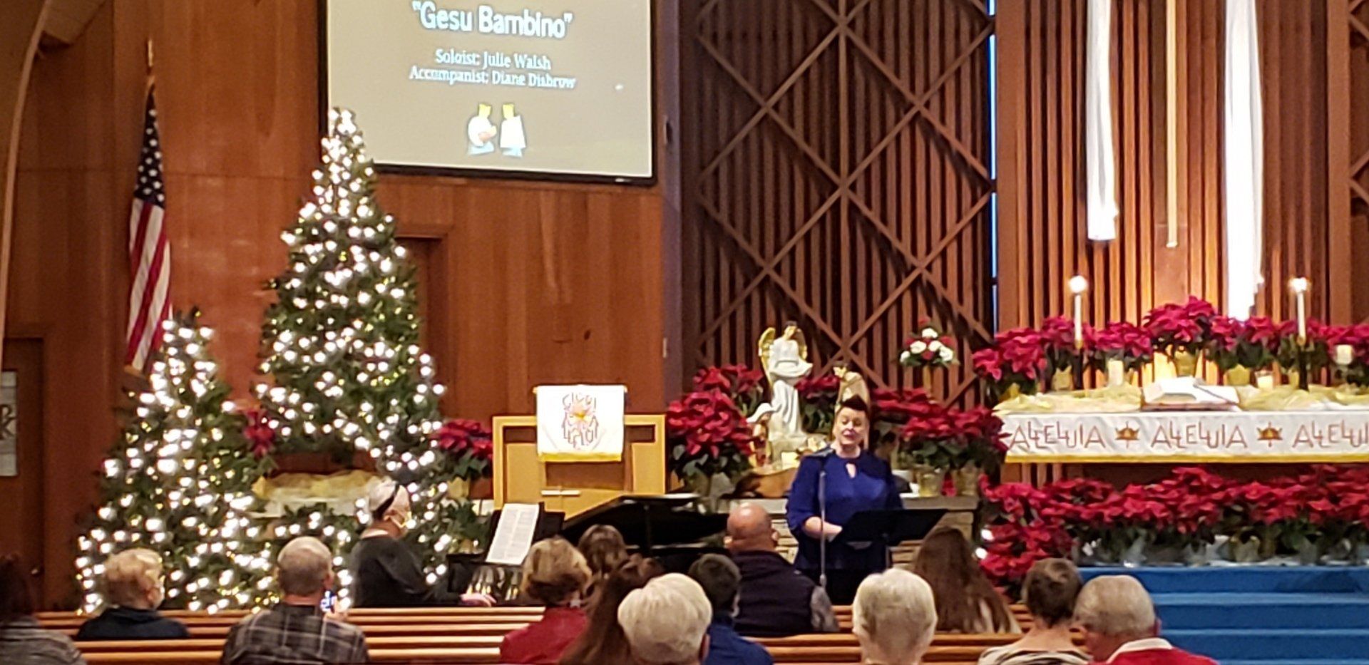 Church sanctuary with decorated Christmas tree, altar, and seated congregation during a holiday service