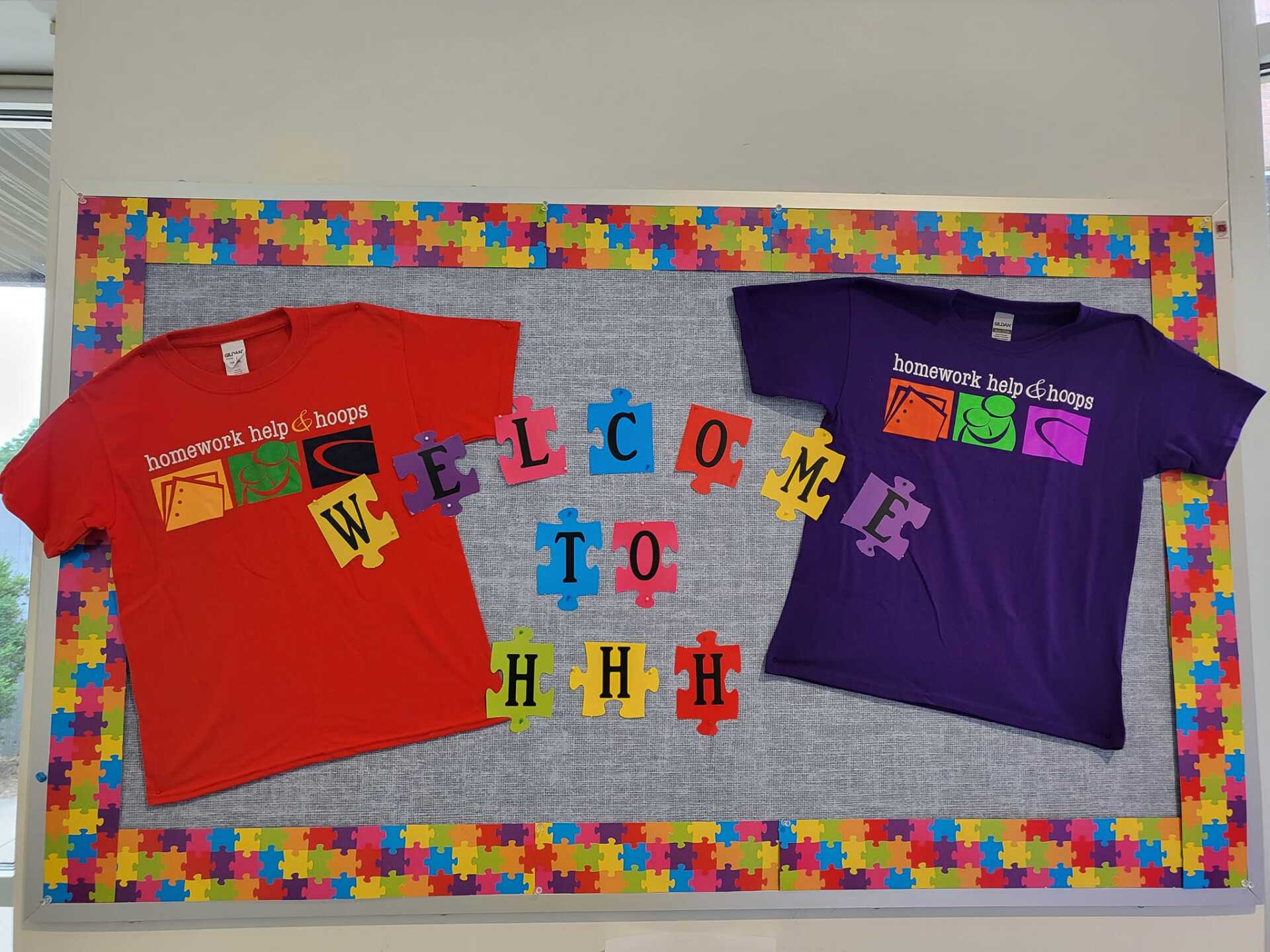 Colorful shirts and letter cards on a bulletin board spelling “welcome to” and “our class”