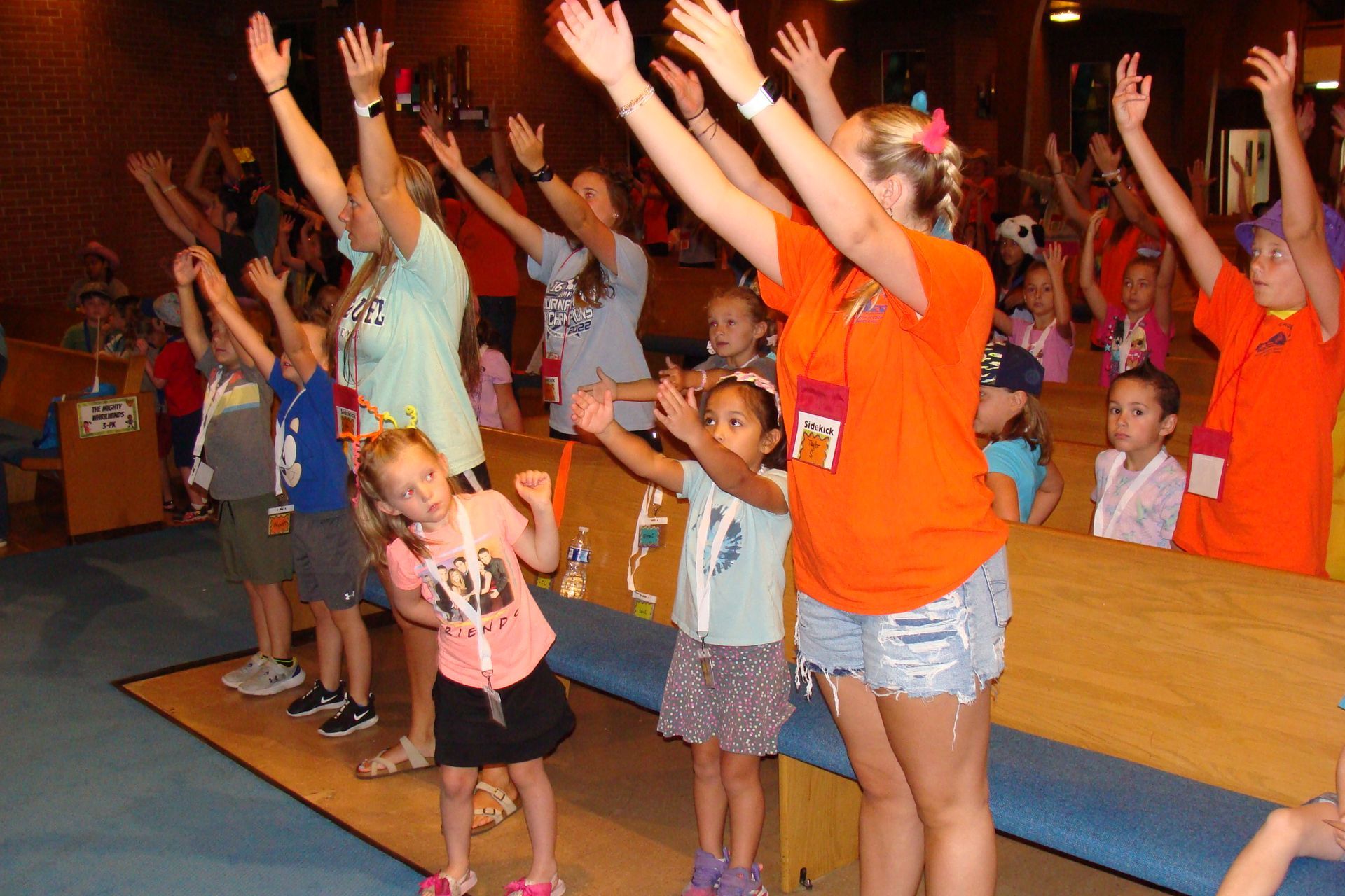 Group of people raising their hands in a colorful indoor activity class