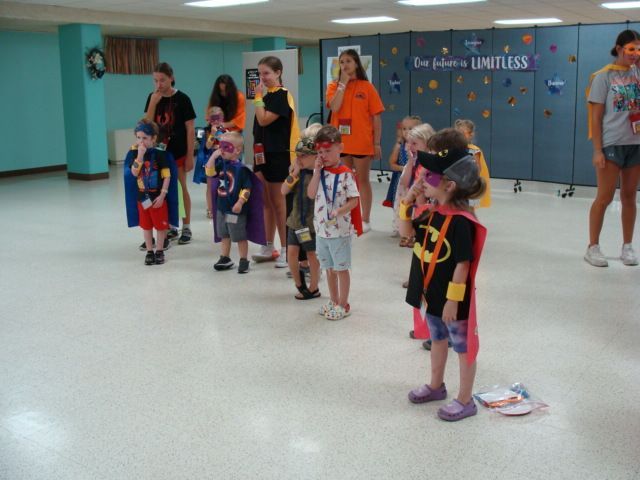 Children in colorful costumes standing in a school hallway during a group activity