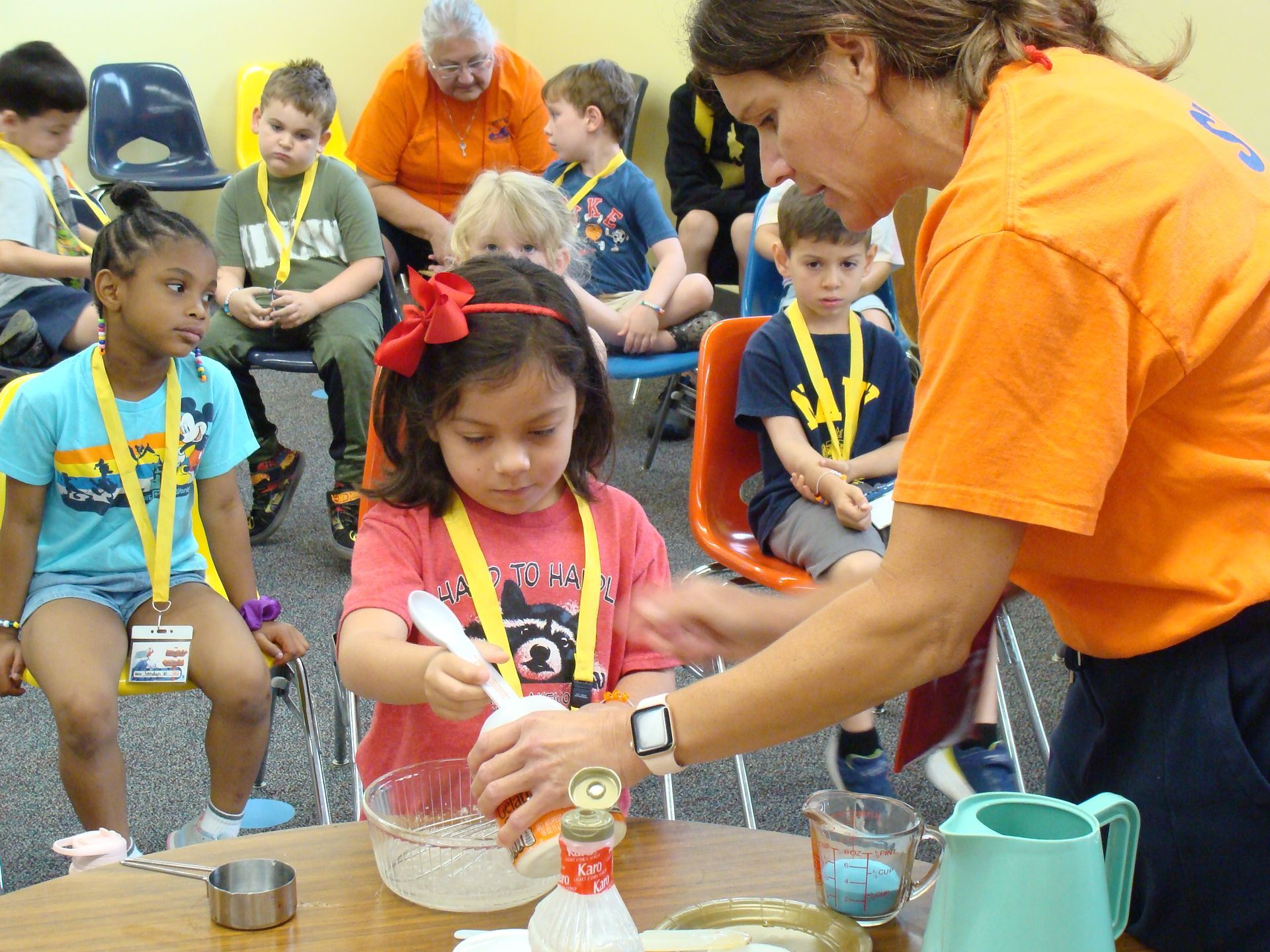 Teacher helping children with a hands-on activity at a table in a classroom
