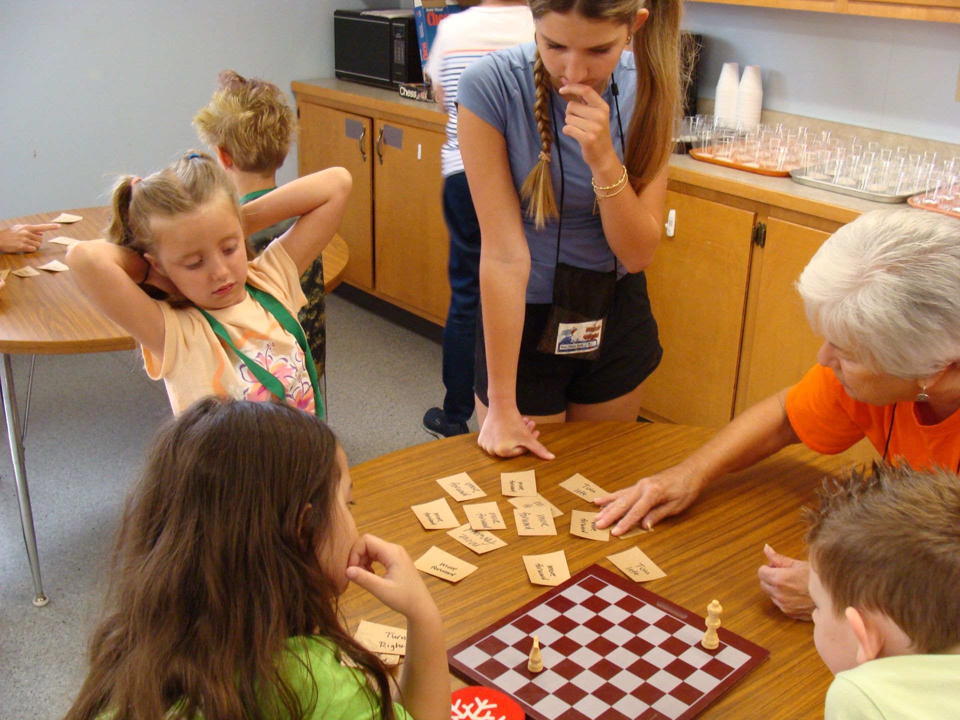 People gathered around a table playing a board game and cards in a room.