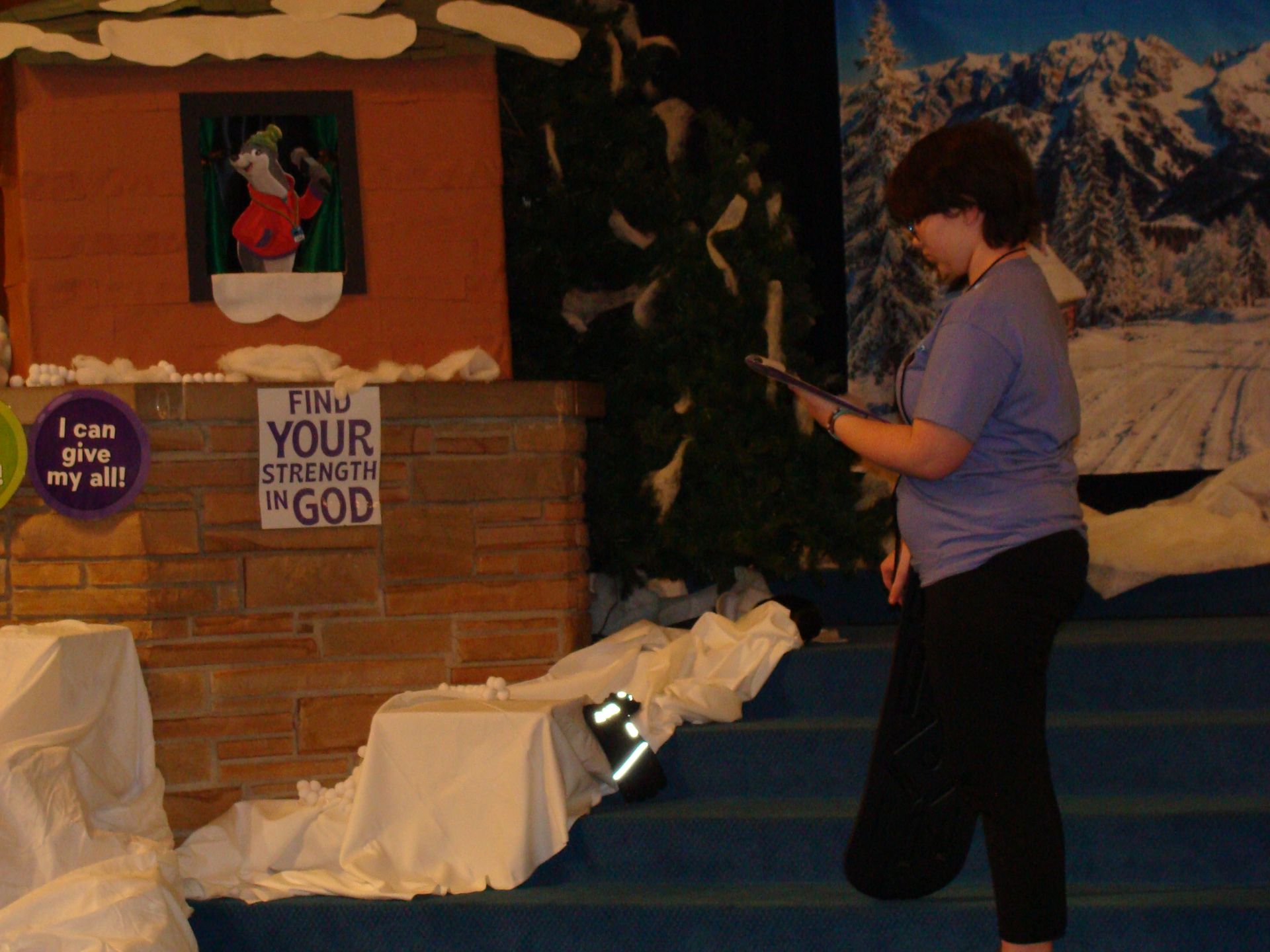 Person speaking at a podium in a church-like room with a sign reading “I am your God.”