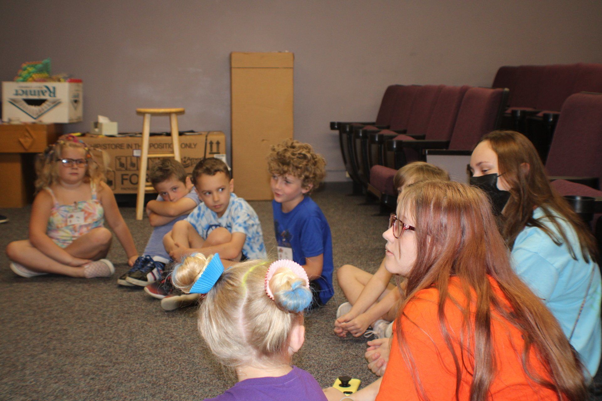 Children sitting in a circle on a carpet during a classroom activity