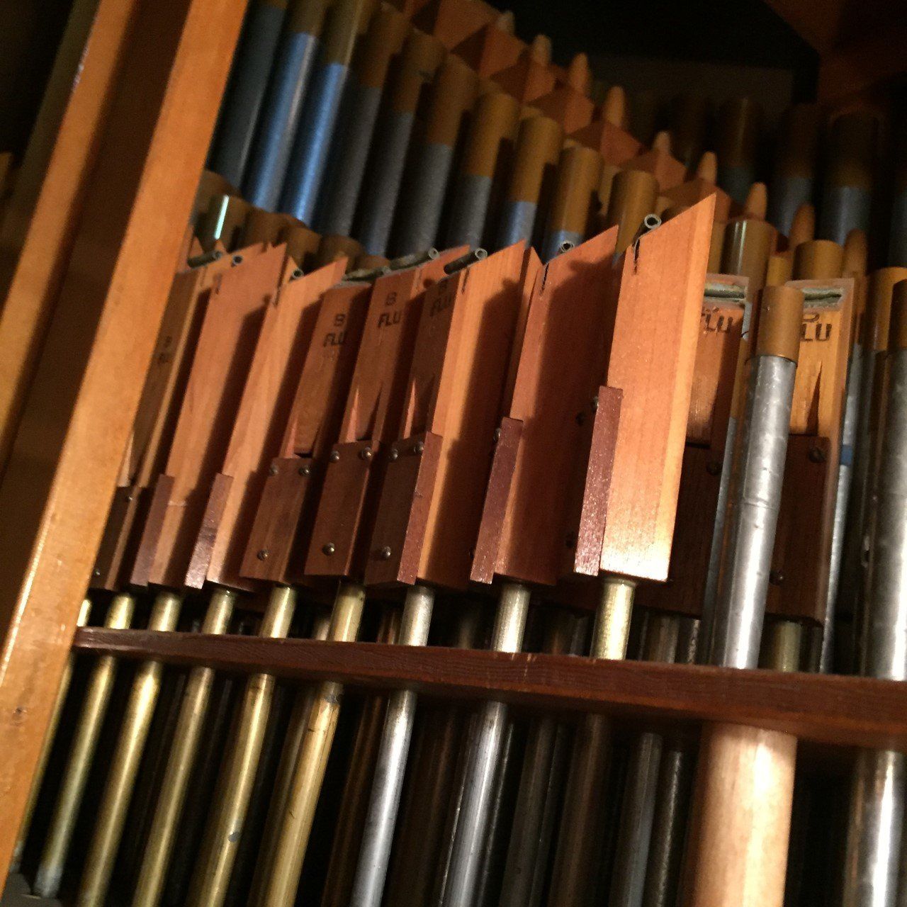 Close-up of assorted wooden and metal pipe organ pipes inside a cabinet