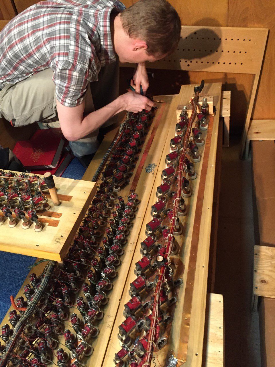 Person inspecting rows of mechanical components on a workbench in a workshop