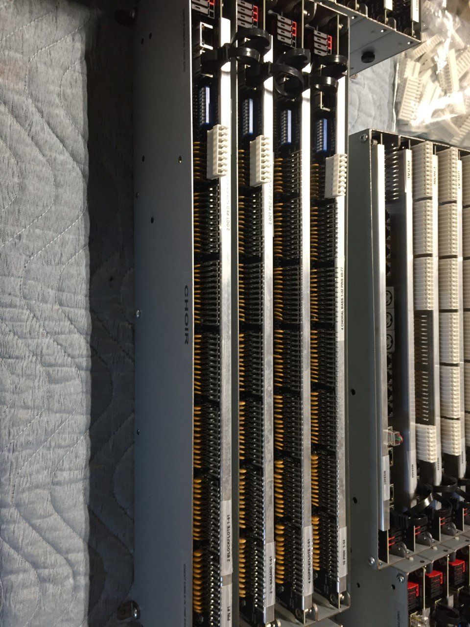 Electrical panel with rows of circuit breakers and wiring inside a gray cabinet, shown close-up.