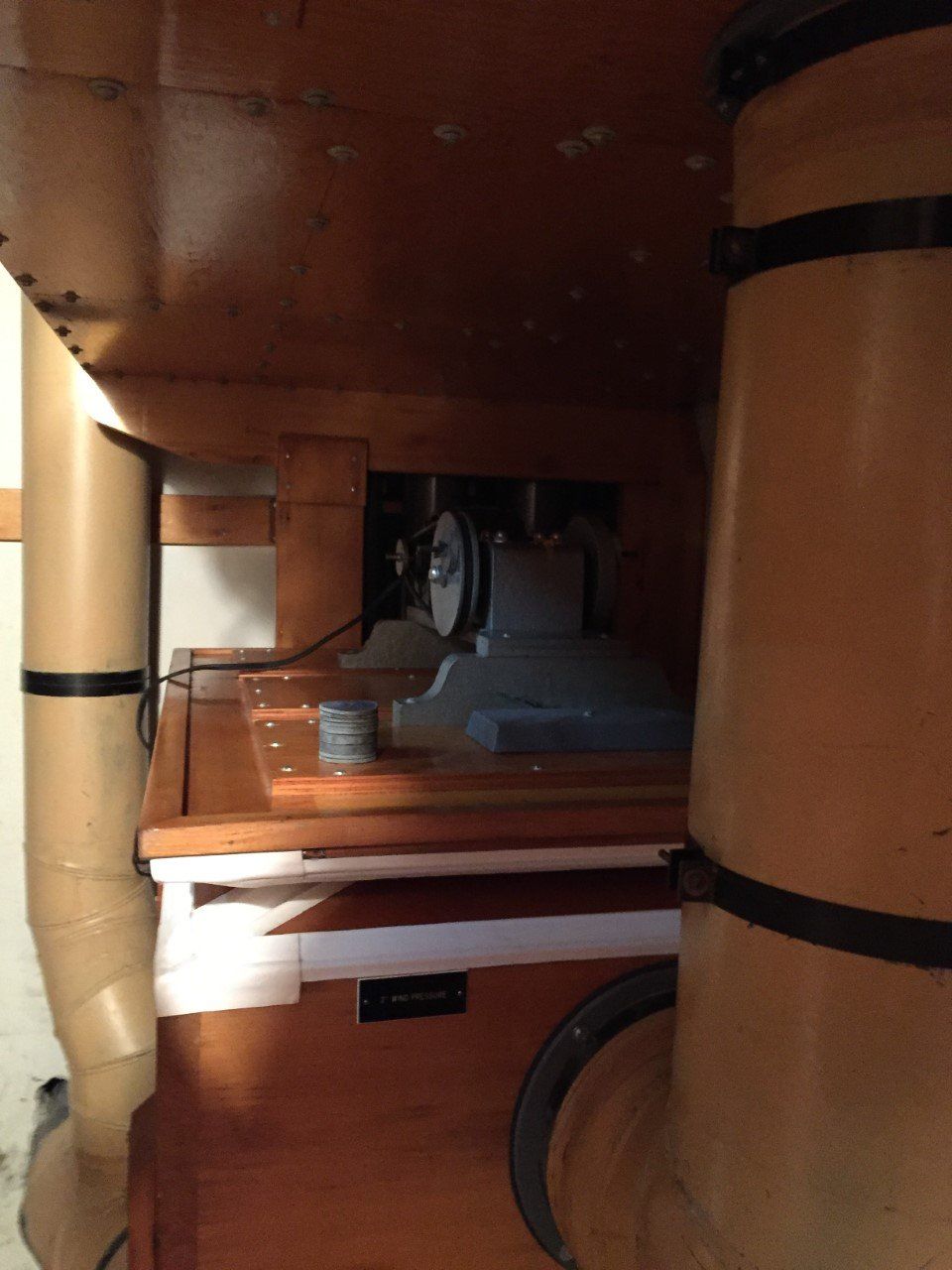 Inside a wooden cabinet, a fan and shelves with stacked items are visible.