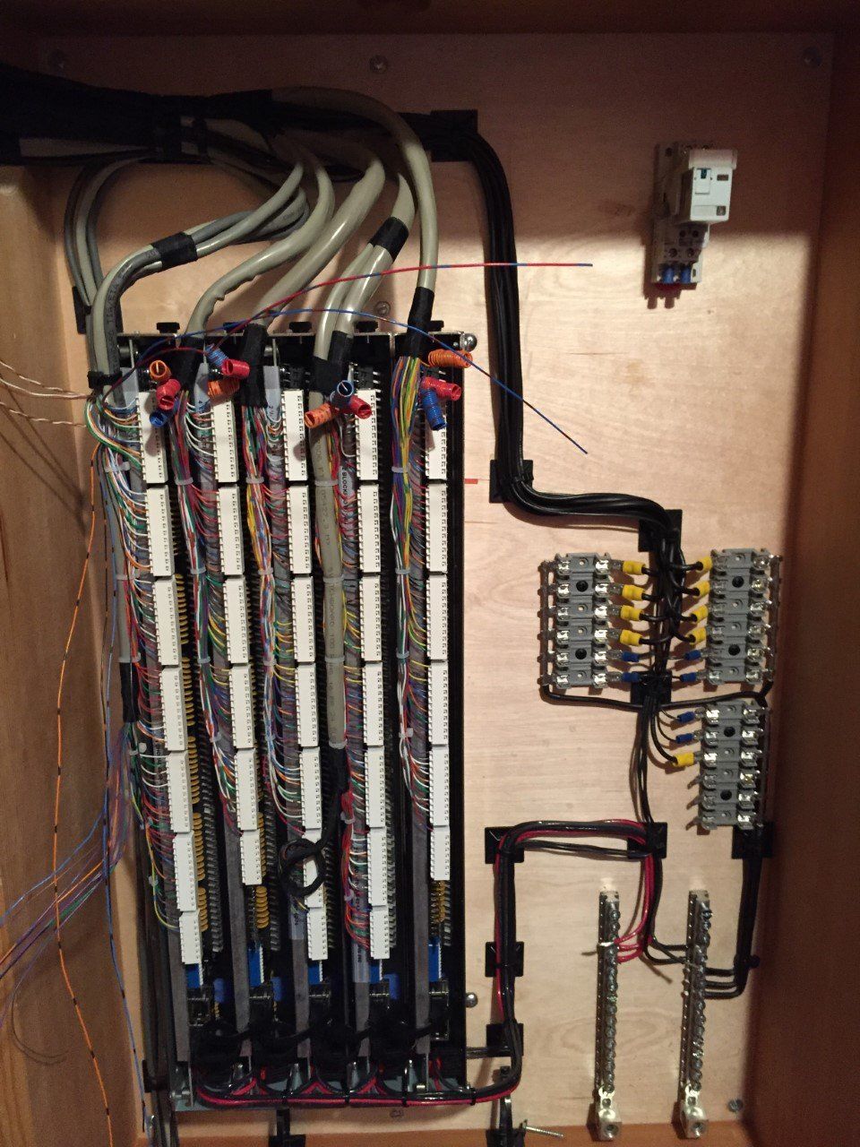 Electrical panel with labeled wires, circuit breakers, and terminal blocks inside a cabinet