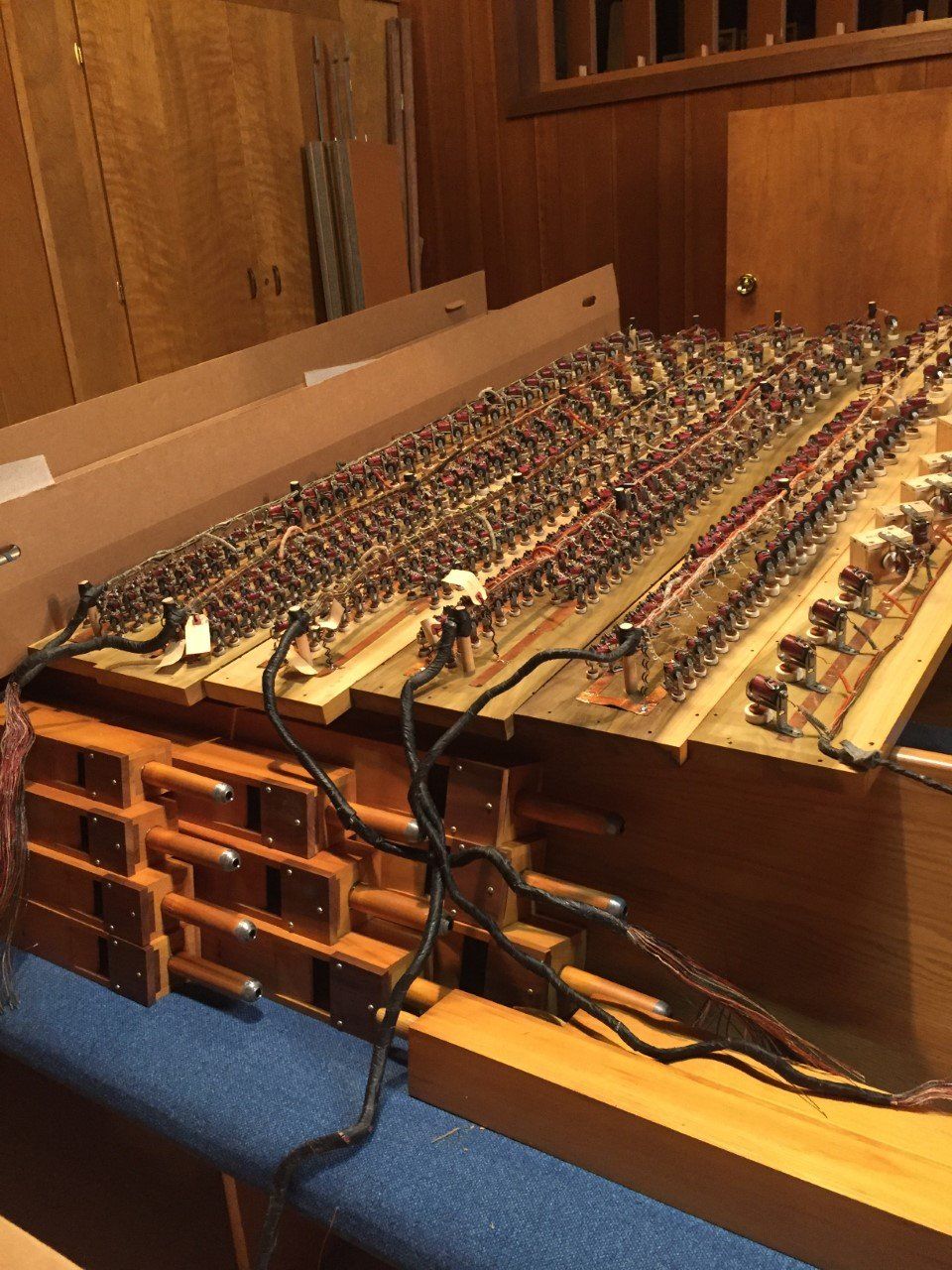 Interior of a mechanical switchboard with rows of wires and terminals on wooden panels