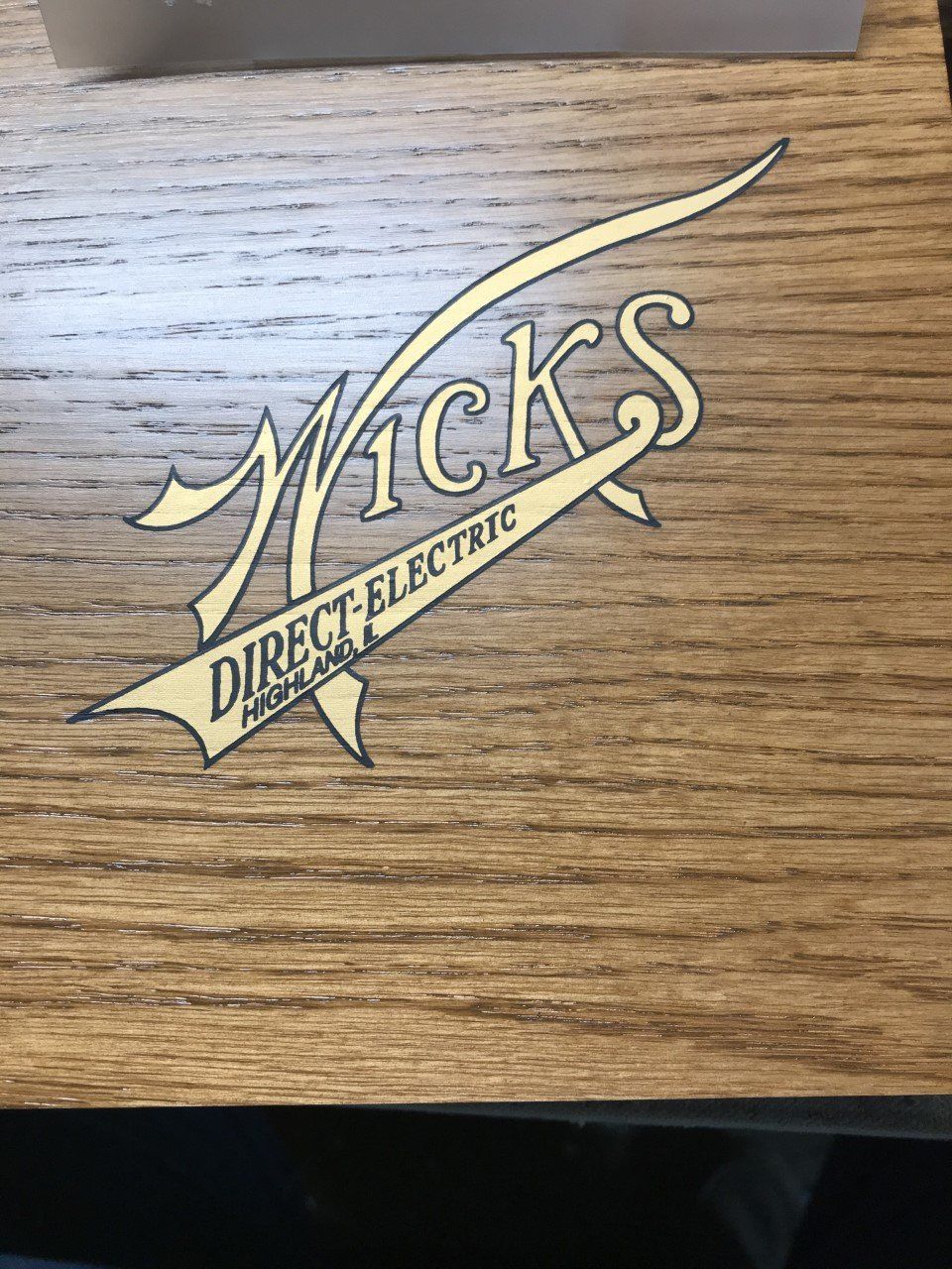 Engraved McK’s Direct Electric logo on a wood surface