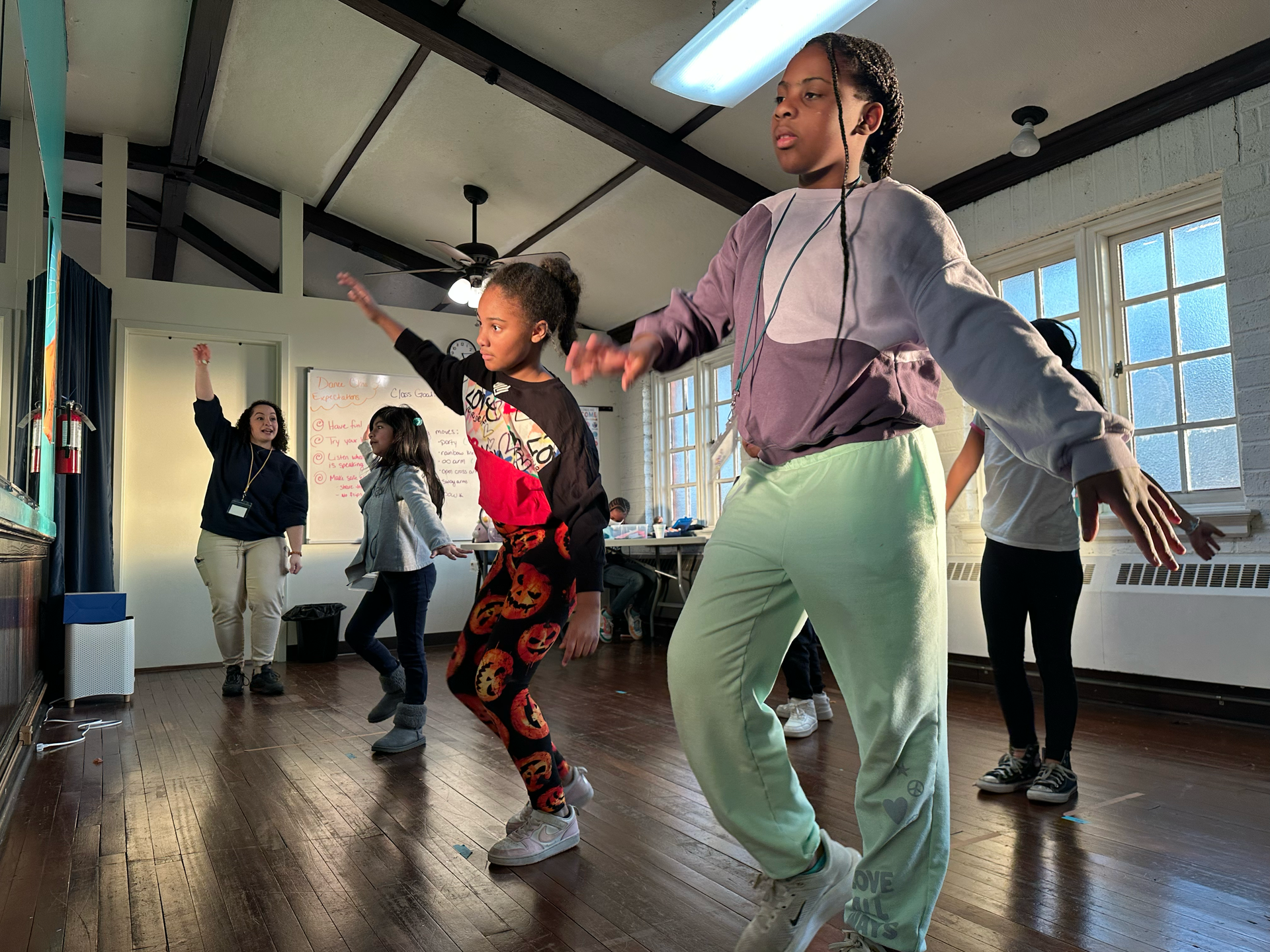 A group of young girls are dancing in a room.