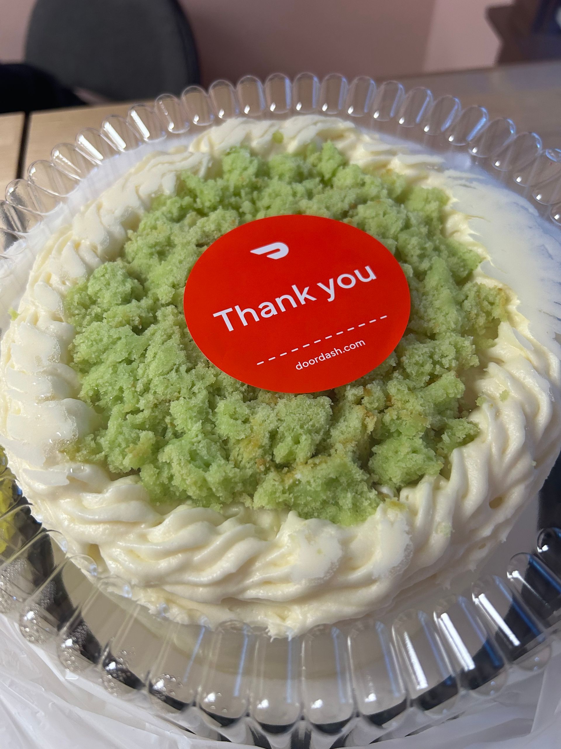 Cake with white frosting, green topping, and a 