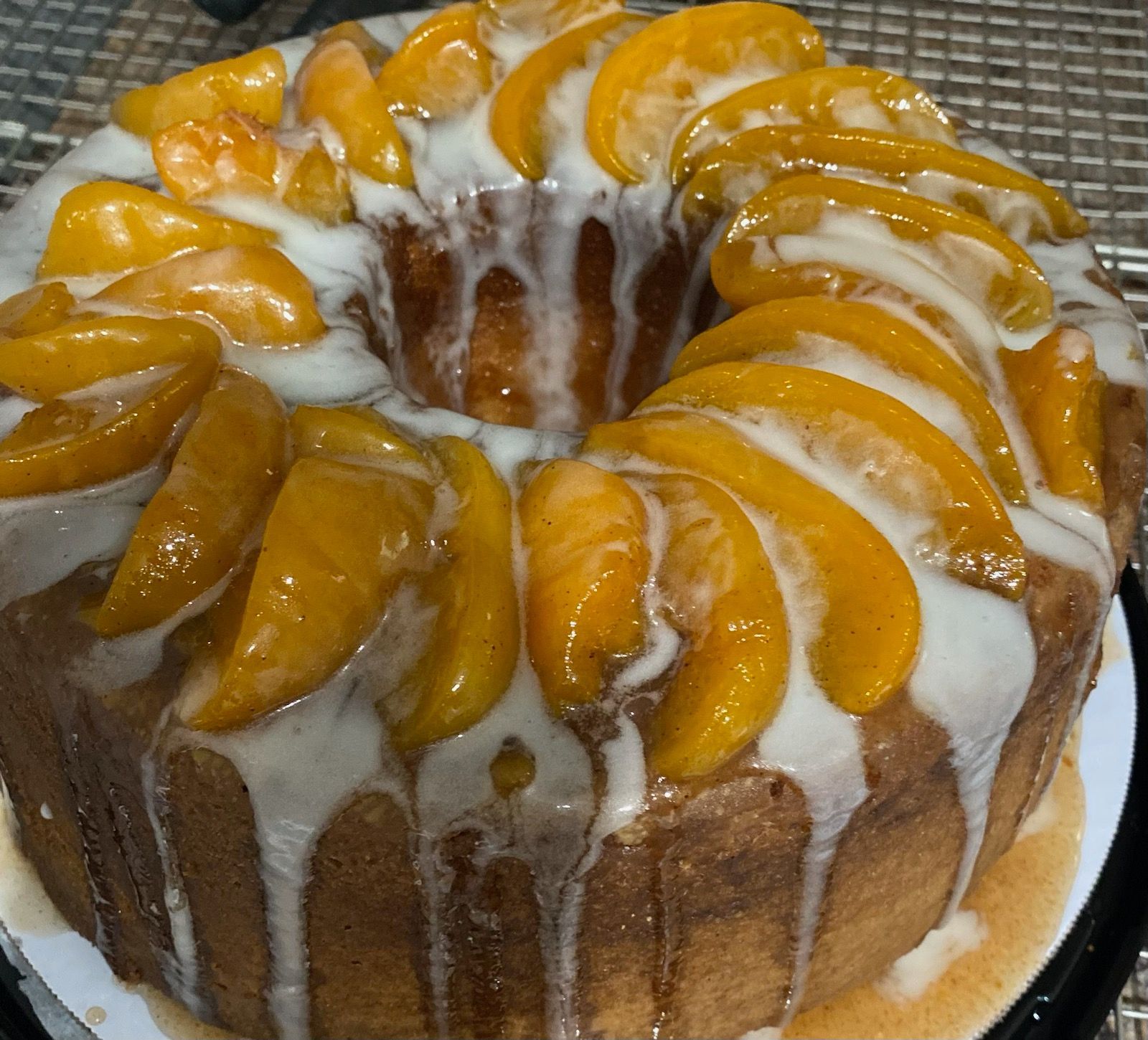 Bundt cake with peach slices and white glaze.