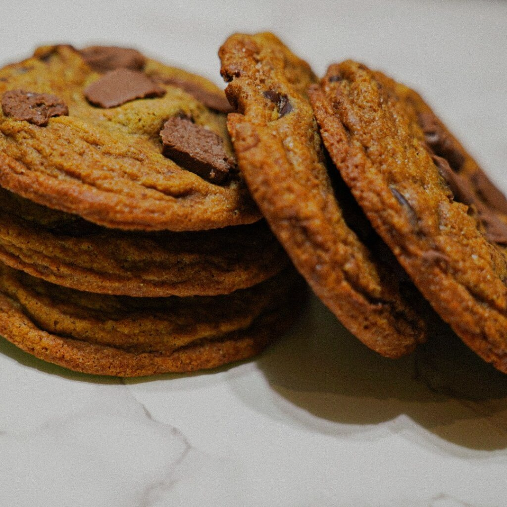 Stack of chocolate chip cookies with a light brown, textured surface.