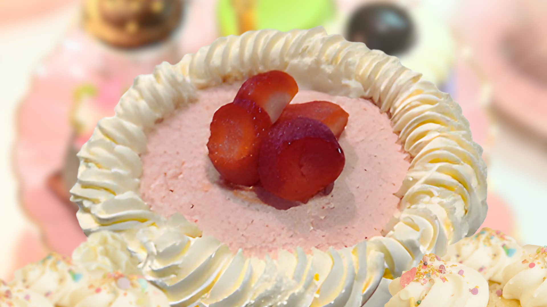 Small pink cake with whipped cream frosting and sliced strawberries.
