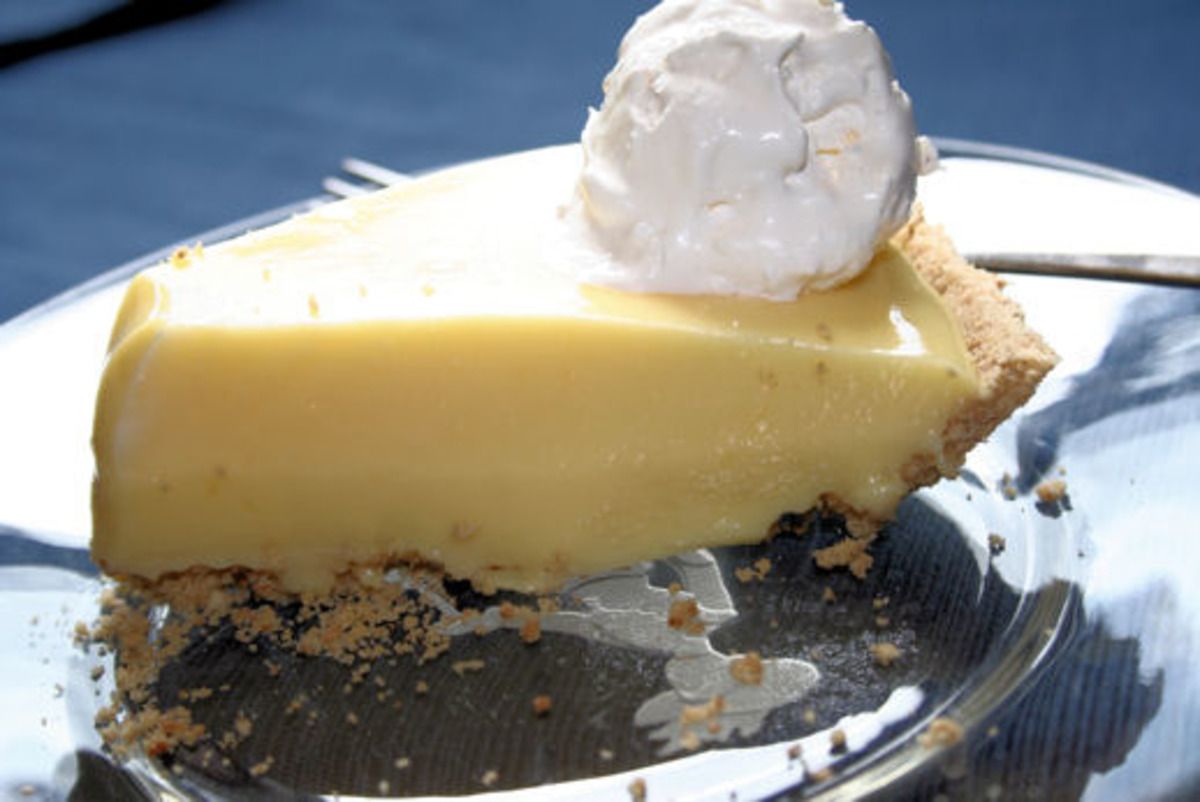 Slice of key lime pie with whipped cream on a plate.