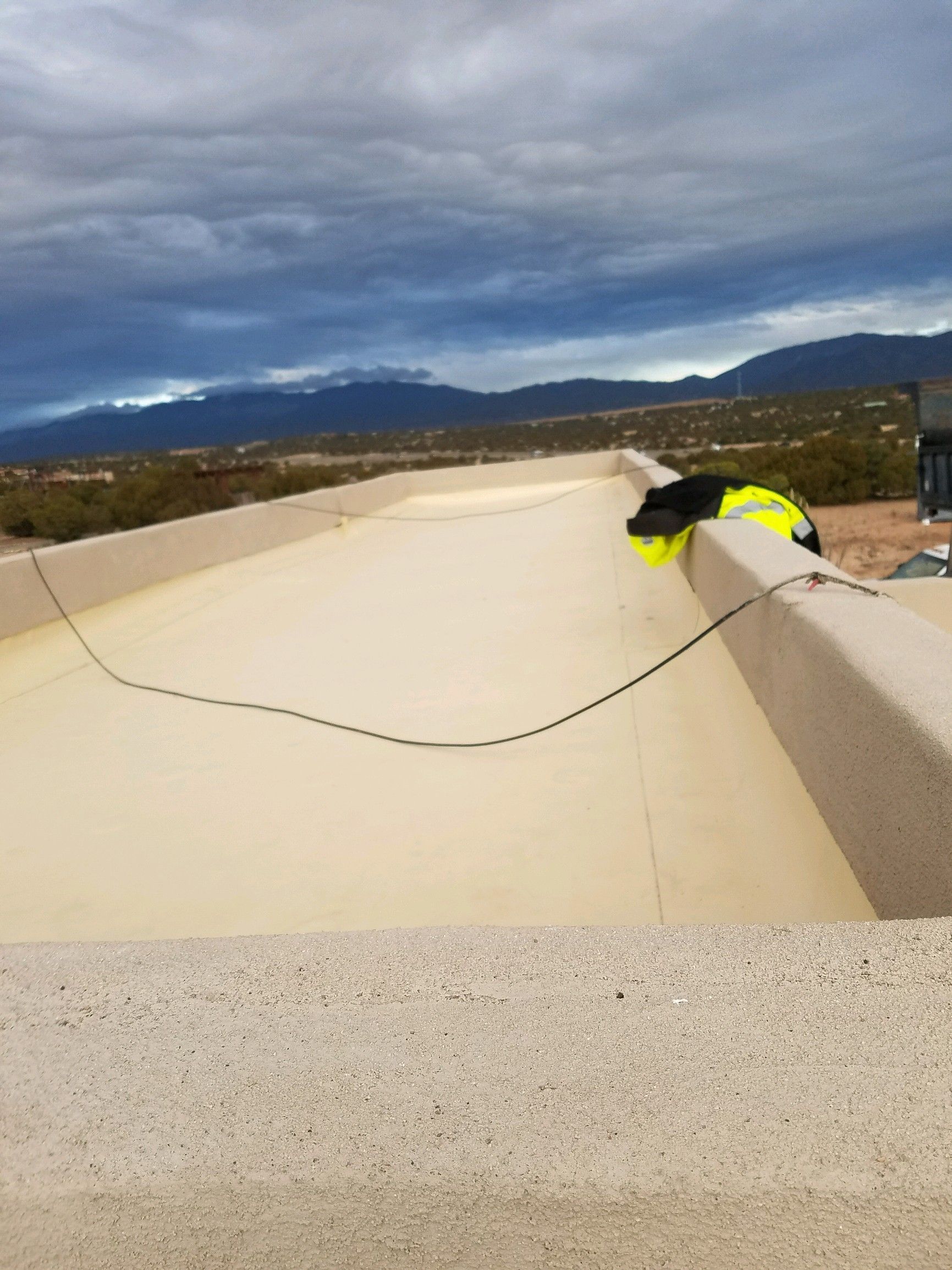 Gloved hands installing terracotta roof tiles on a sloped roof