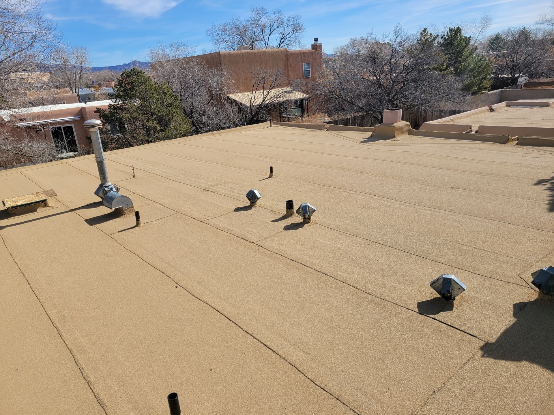 Gloved hands installing terracotta roof tiles on a sloped roof