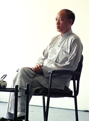 A man is sitting in a chair with his legs crossed