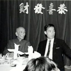 A black and white photo of two men sitting at a table