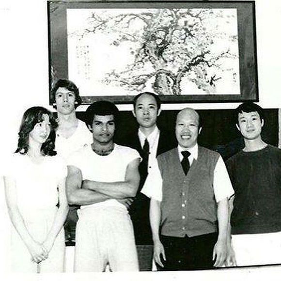A group of people standing in front of a painting