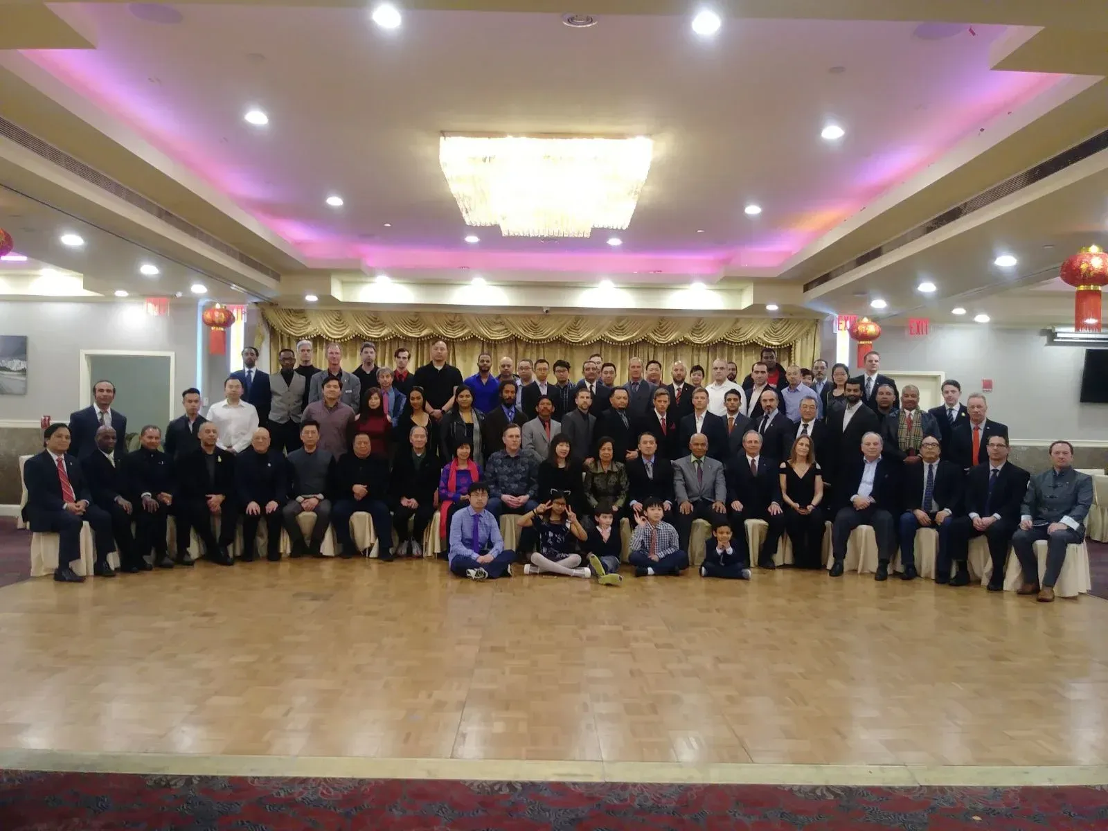 A large group of people are posing for a picture in a large room.