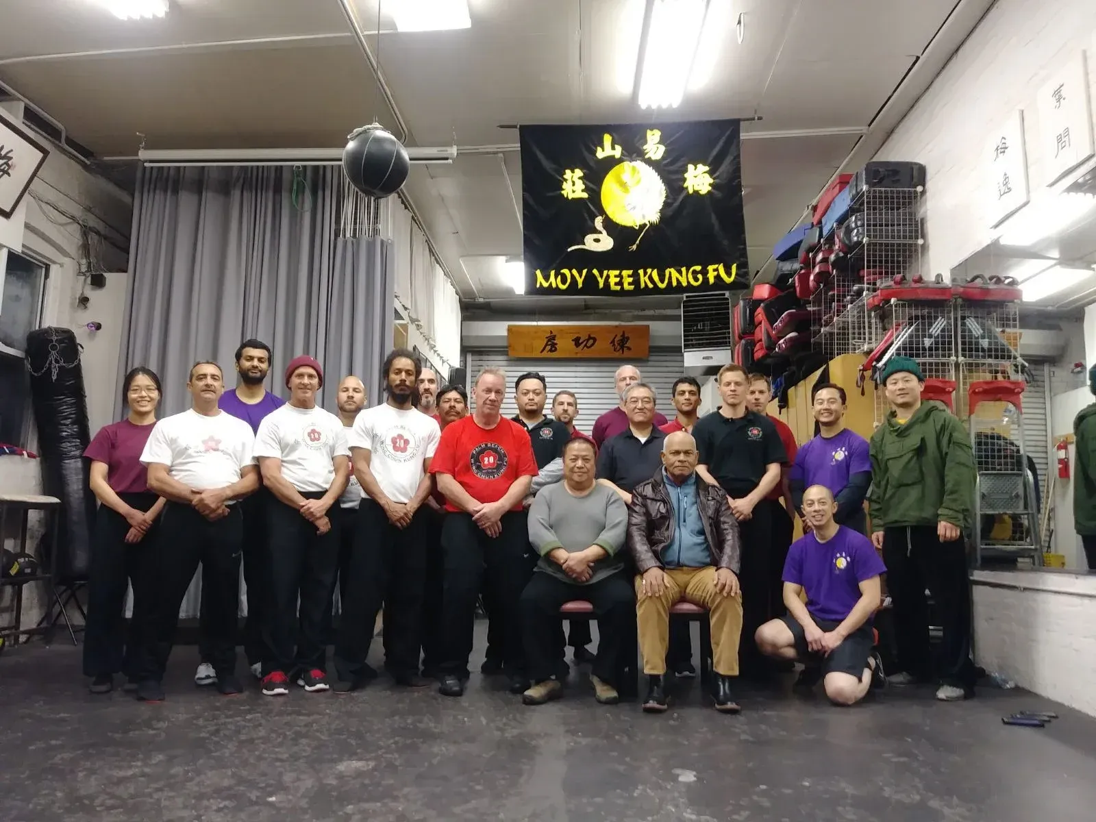 A group of people are posing for a picture in a gym.
