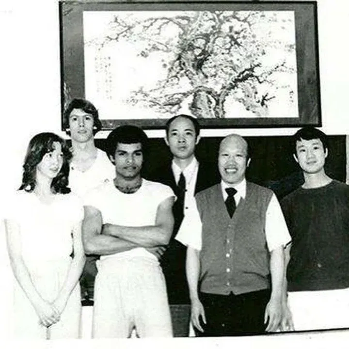 A group of people standing in front of a painting