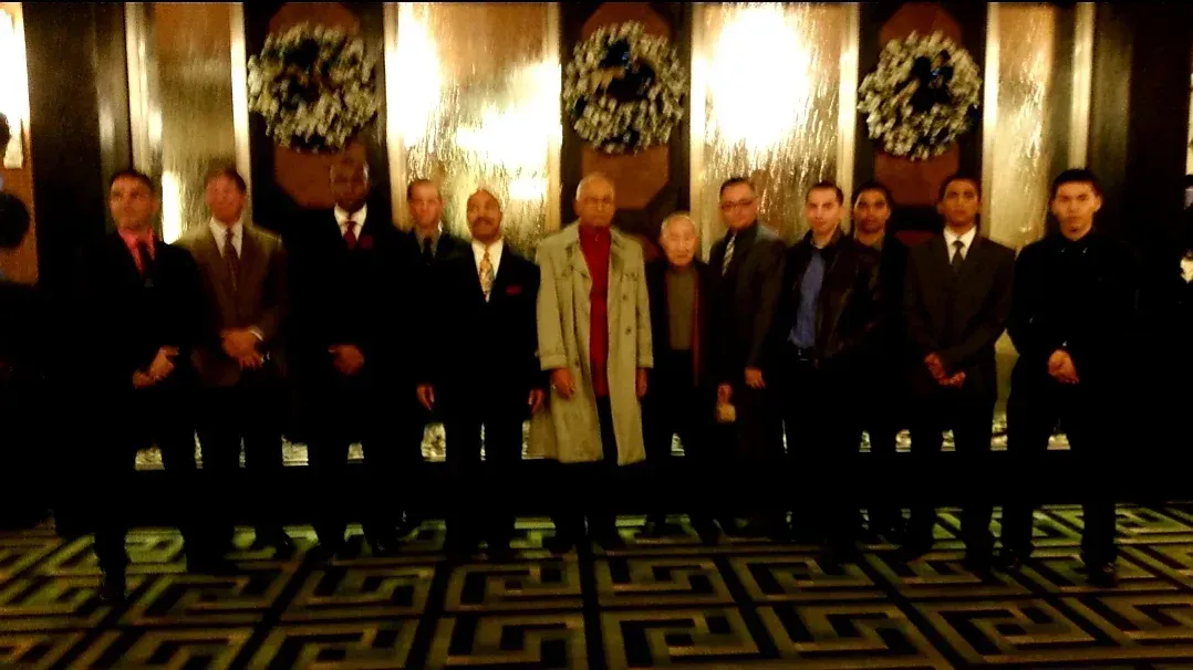 A group of men are posing for a picture in a dark room
