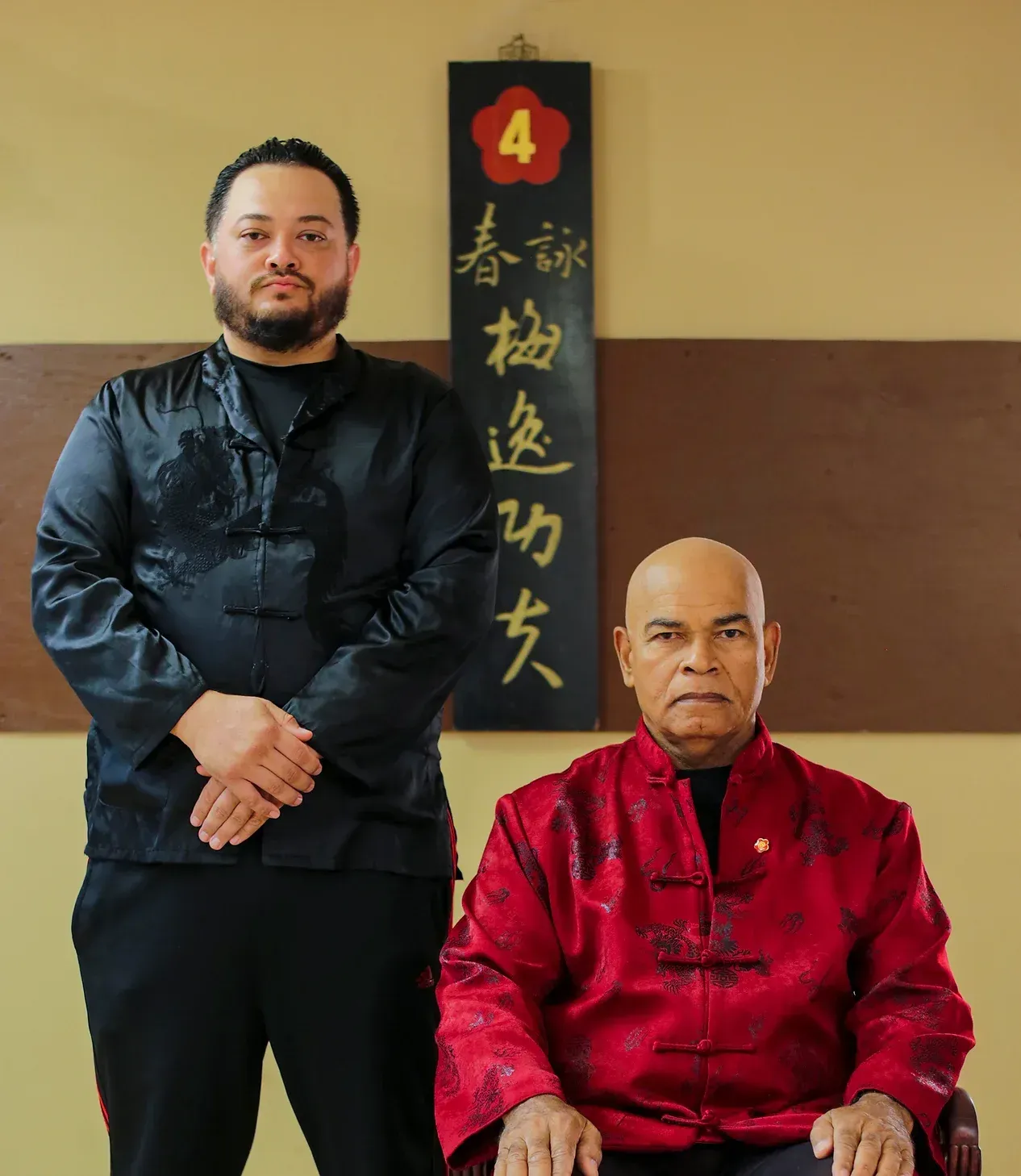 Two men standing next to each other in front of a sign that says 4