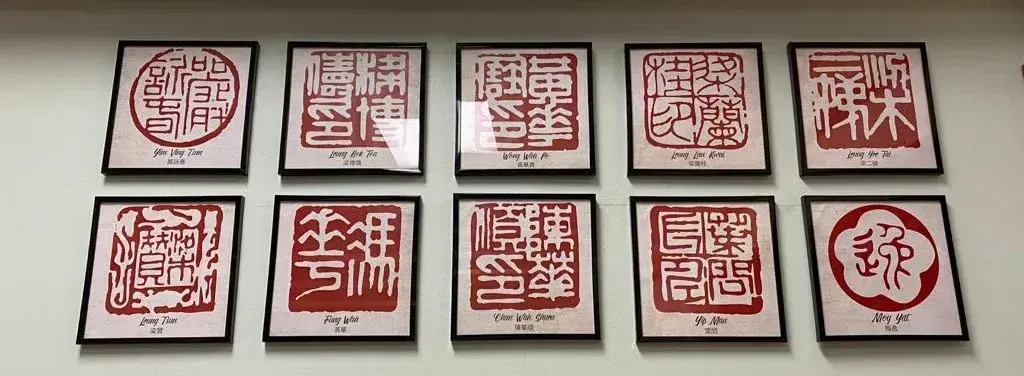 A row of framed chinese stamps on a wall