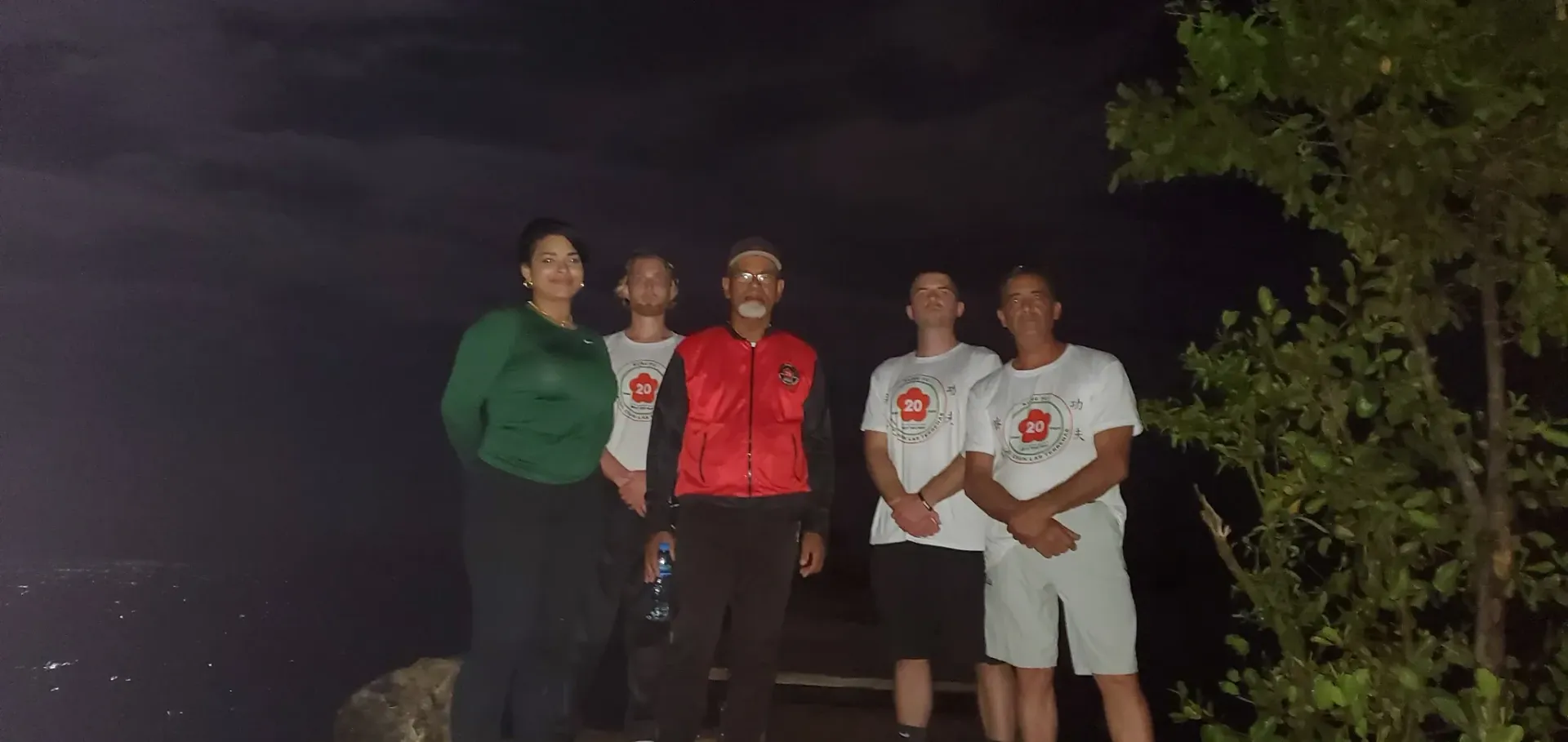 A group of people are standing next to each other in the dark.