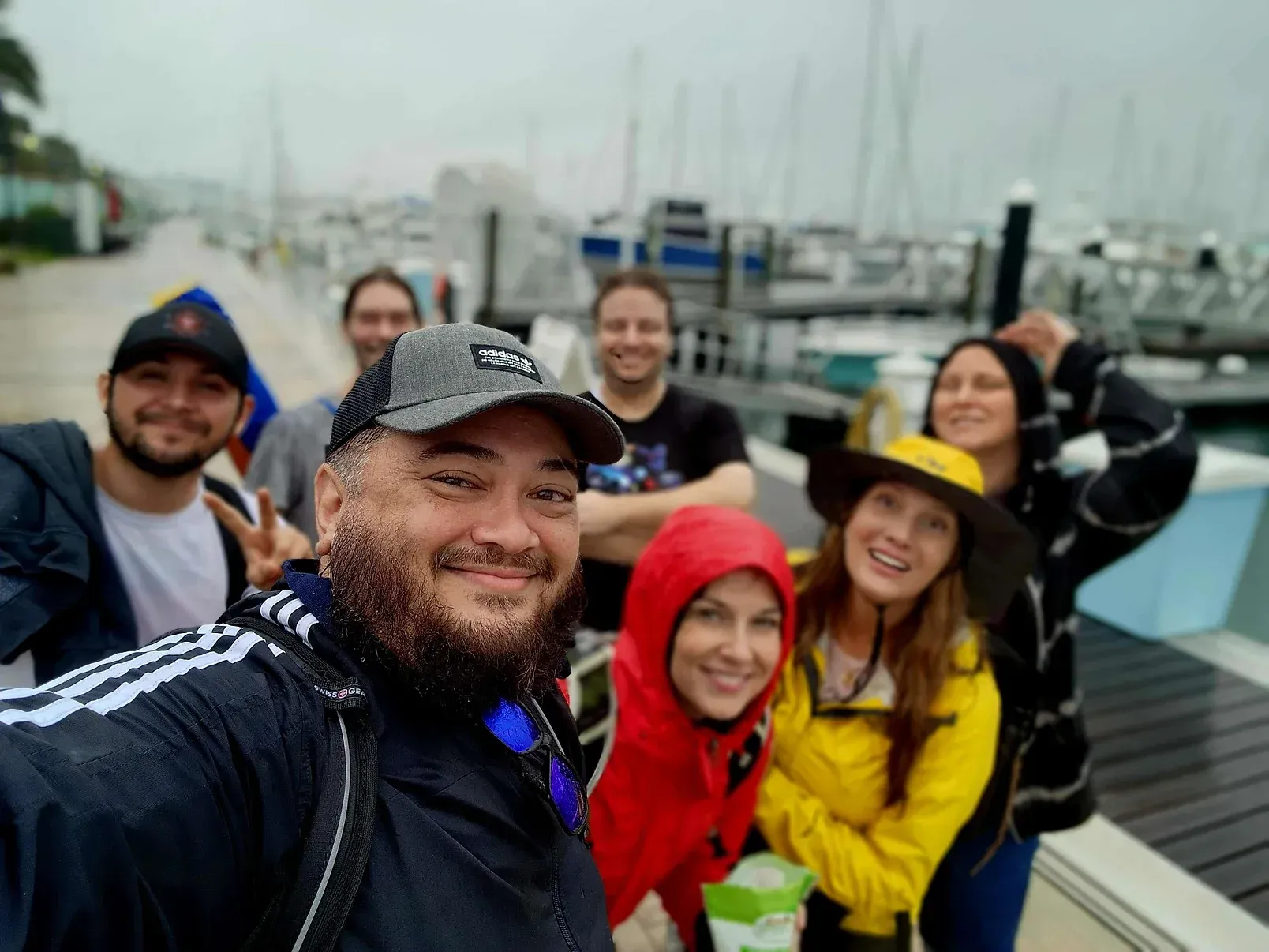 A group of people are posing for a selfie on a dock.