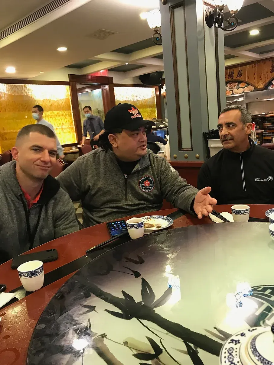 A group of men are sitting at a table in a restaurant.