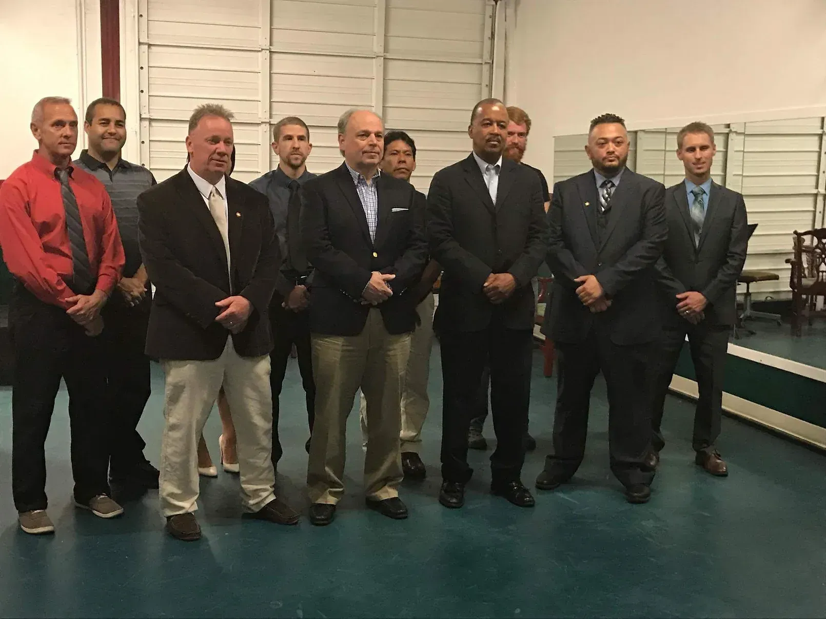 A group of men in suits and ties are standing next to each other in a room.