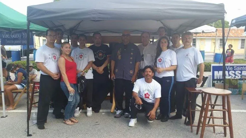 A group of people standing under a tent with a sign that says miss