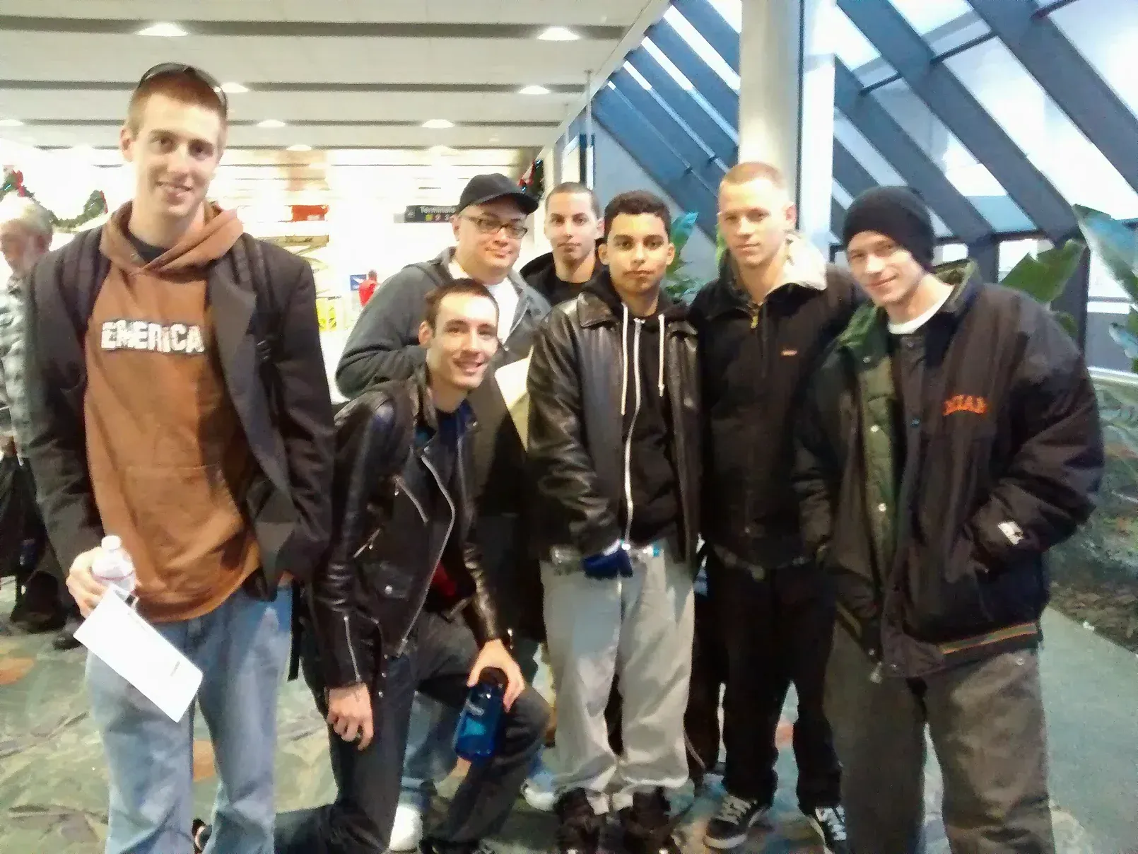 A group of young men are posing for a picture and one of them is wearing a hoodie that says energy