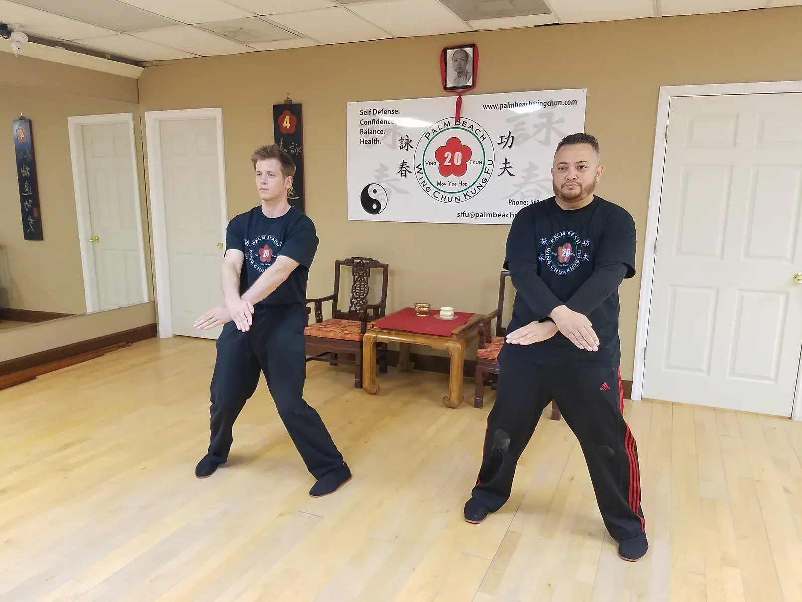Two men are practicing martial arts in a room.