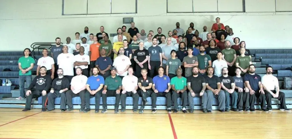 A large group of people are posing for a picture in a gym