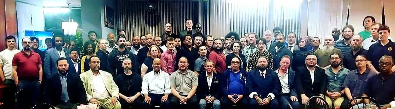 A large group of people are posing for a picture in a room.