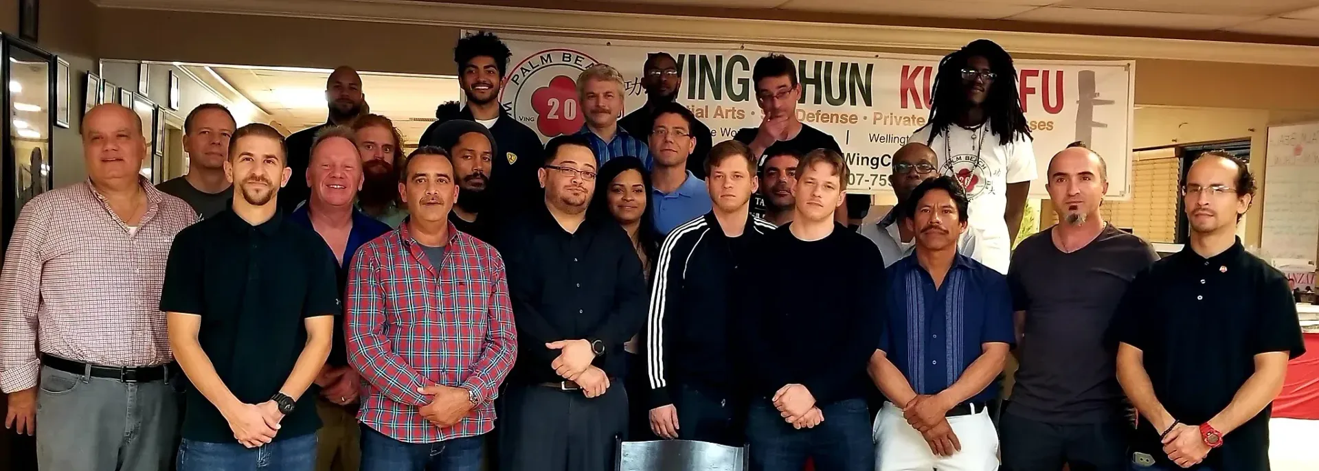 A group of men are posing for a picture in front of a sign that says hun