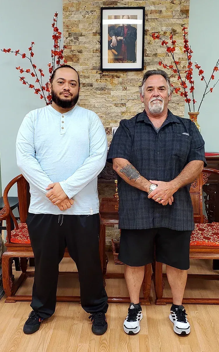 Two men are standing next to each other in a room.