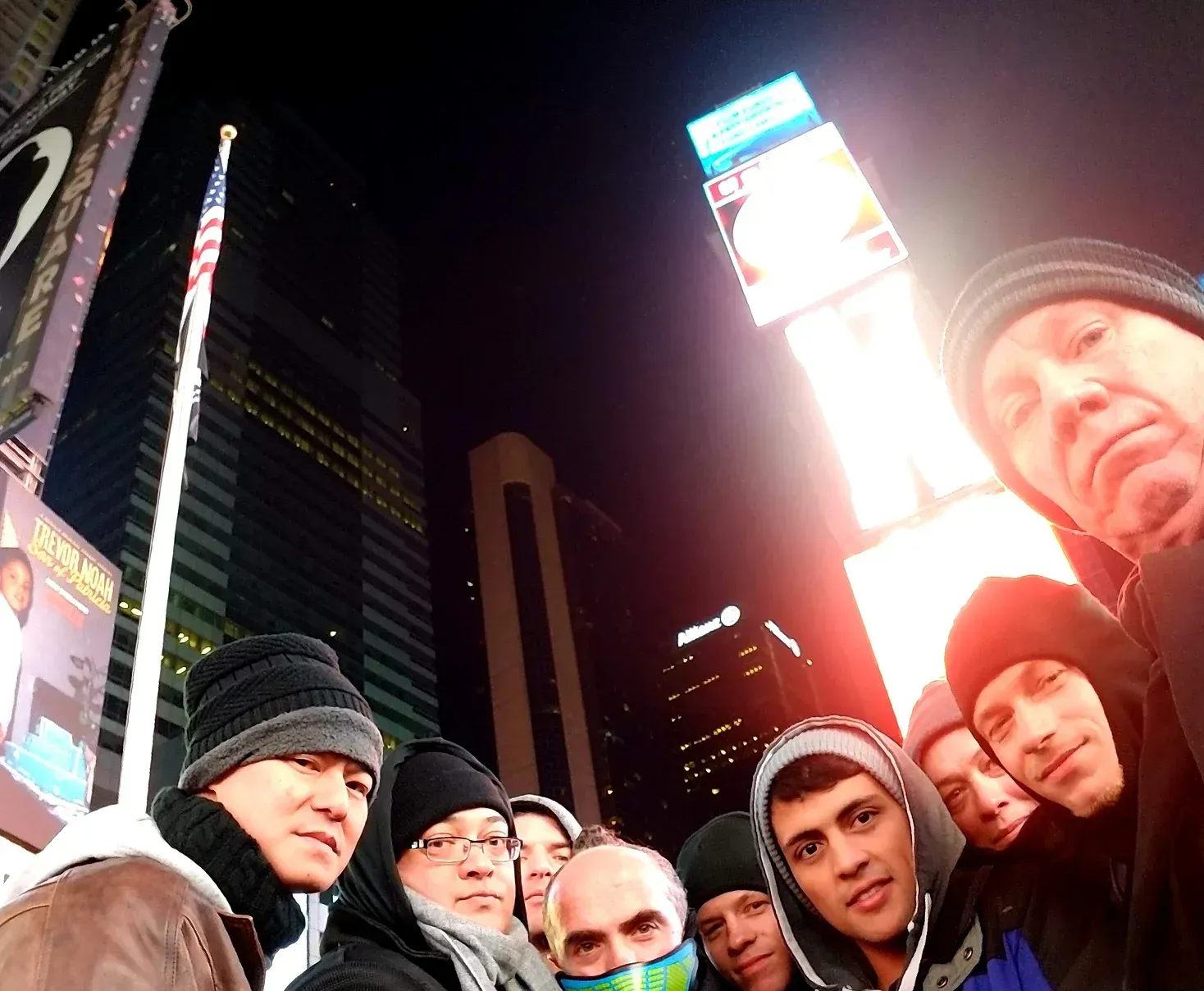 A group of men are posing for a picture in front of a sign that says subway