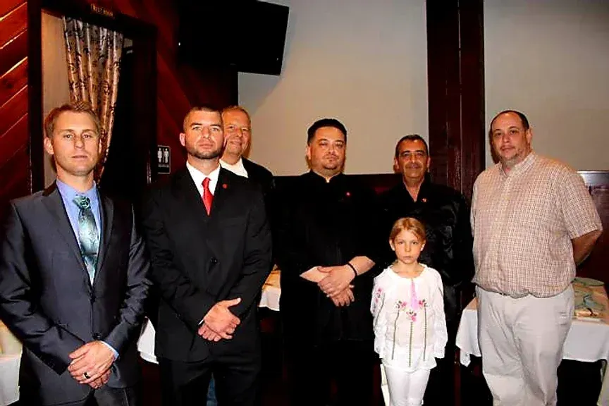 A group of men and a little girl are posing for a picture.