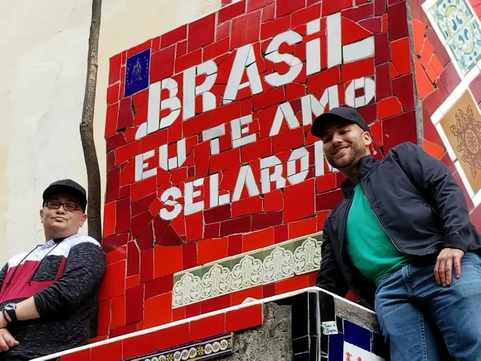 Two men are standing in front of a sign that says brasil eu te amo selaron