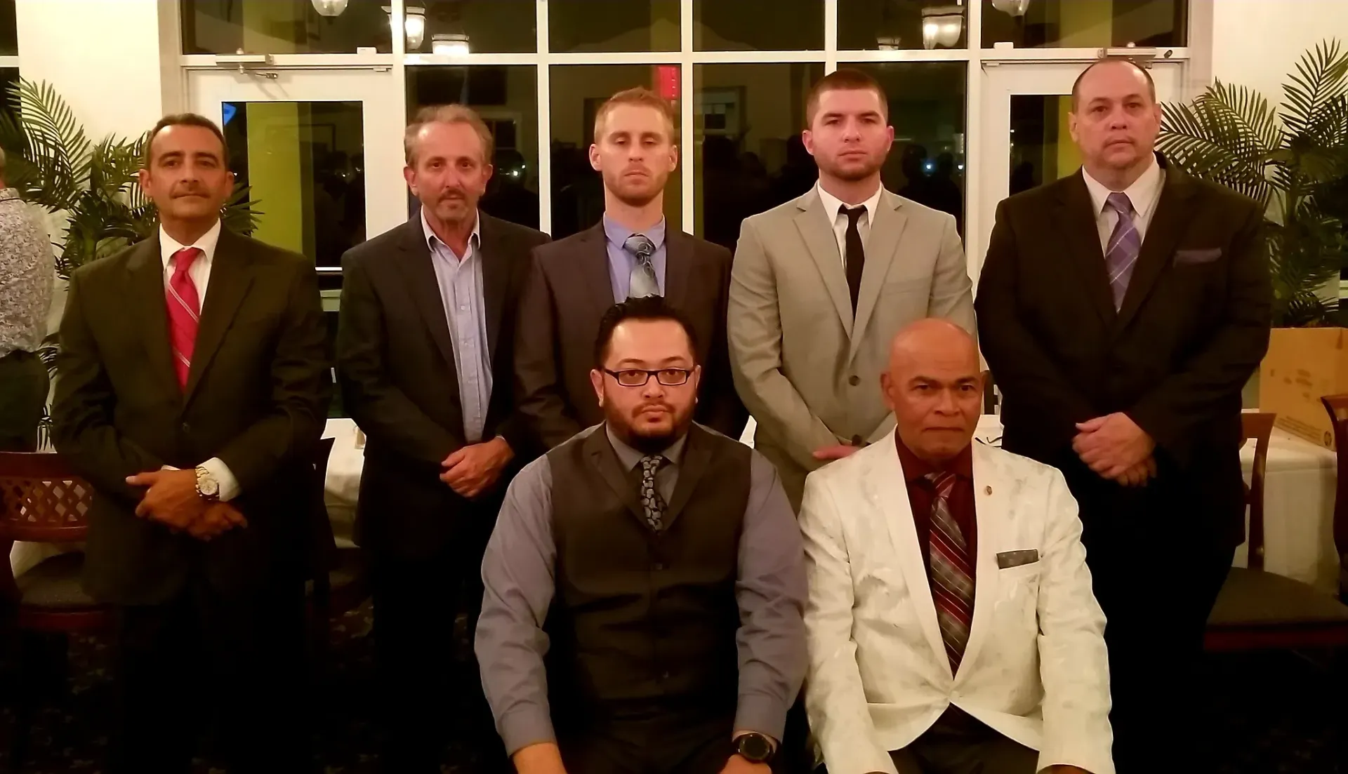 A group of men in suits and ties are posing for a picture.