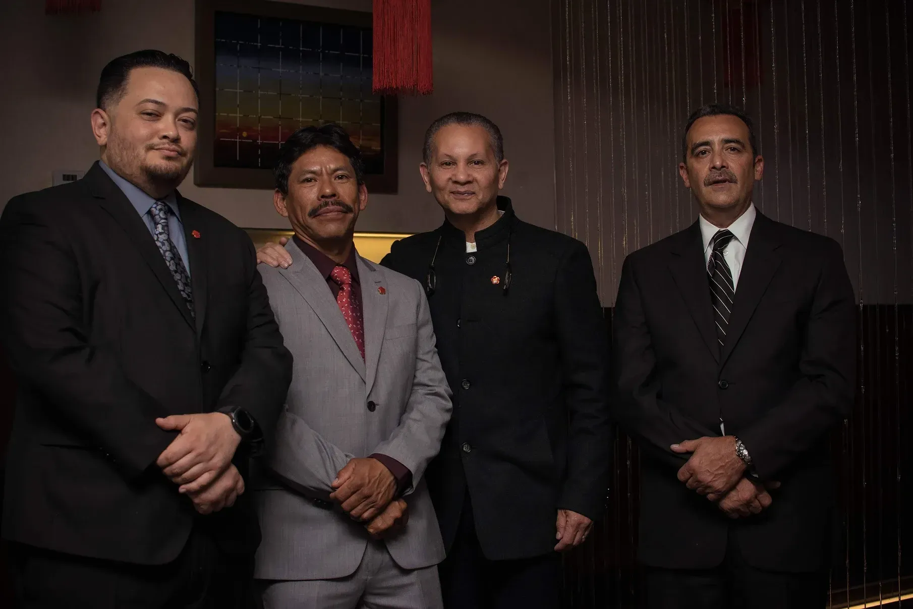 A group of men in suits and ties are posing for a picture.