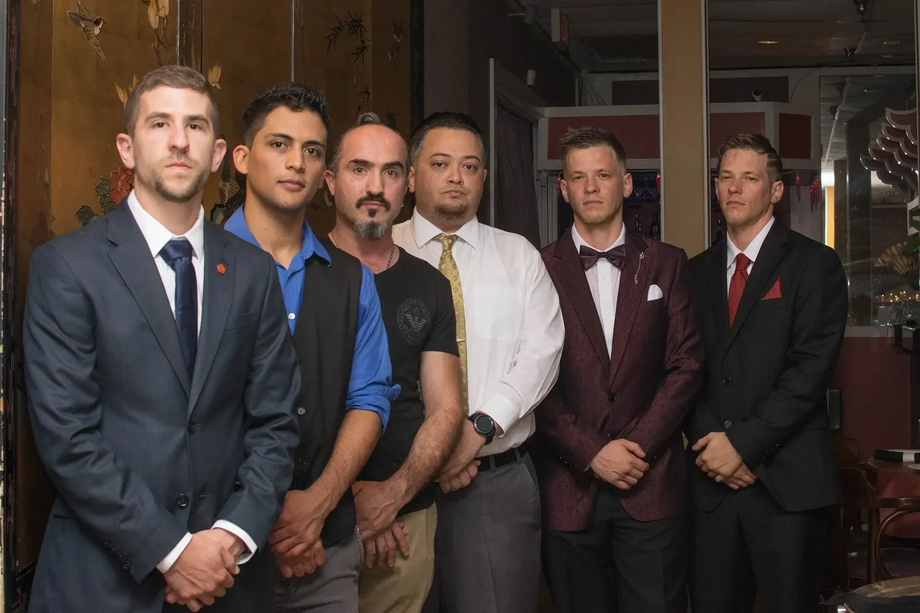 A group of men in suits and ties are posing for a picture.