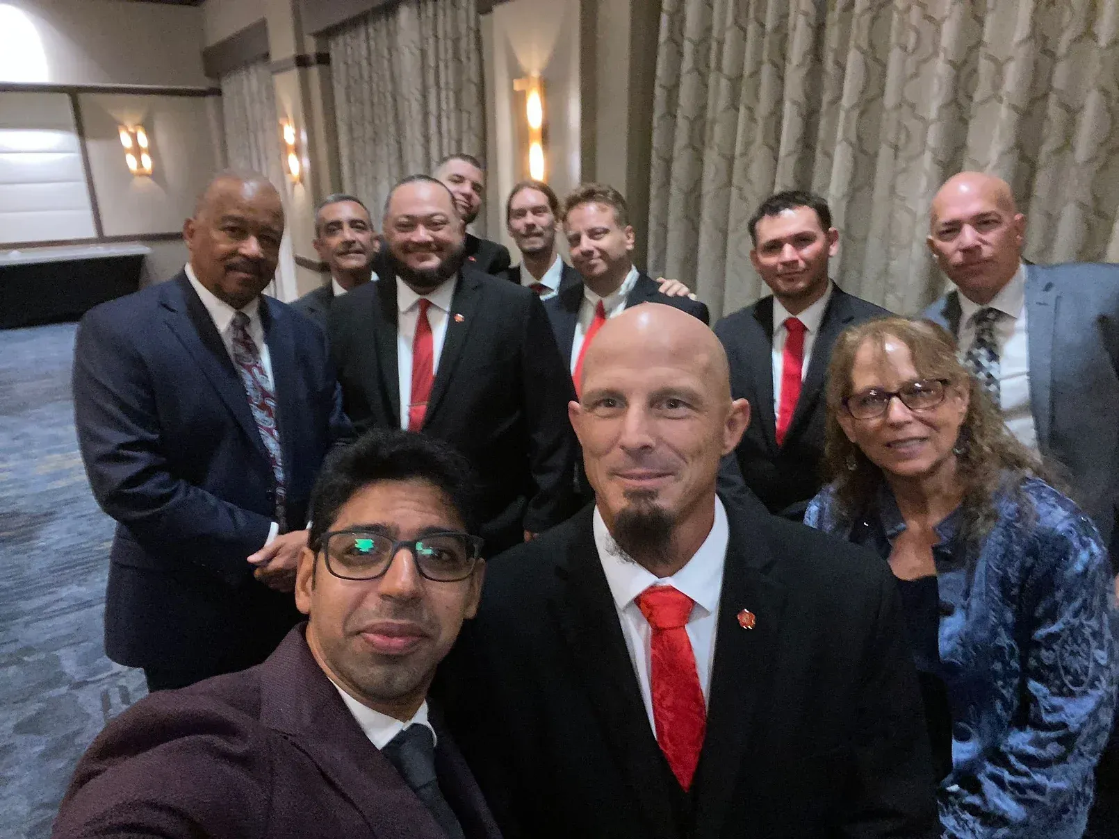 A group of men in suits and ties are posing for a picture